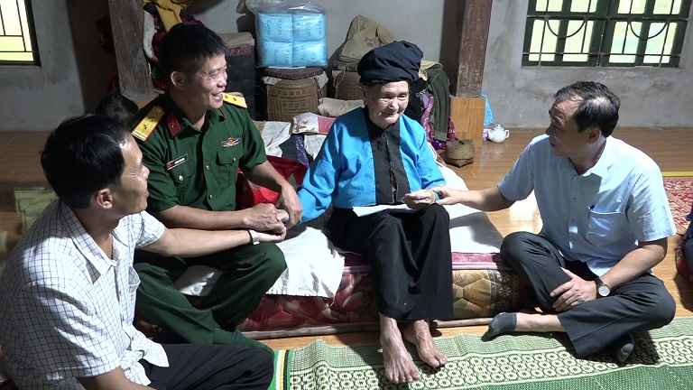 Đồng chí Hoàng Văn Dũng - Ủy viên BTV Huyện ủy, Phó Chủ tịch Thường trực UBND thăm tặng quà mẹ liệt sỹ Vi Thị Khặt (bản Na Chừa)