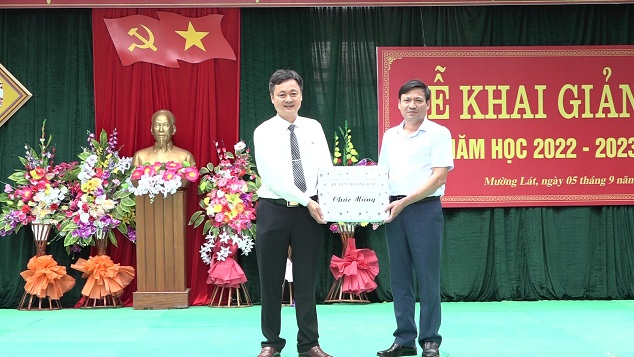 Đồng chí Nguyễn Văn Bình - Phó Bí thư Huyện ủy, Chủ tịch UBND huyện tặng quà chúc mừng buổi lễ khai giảng