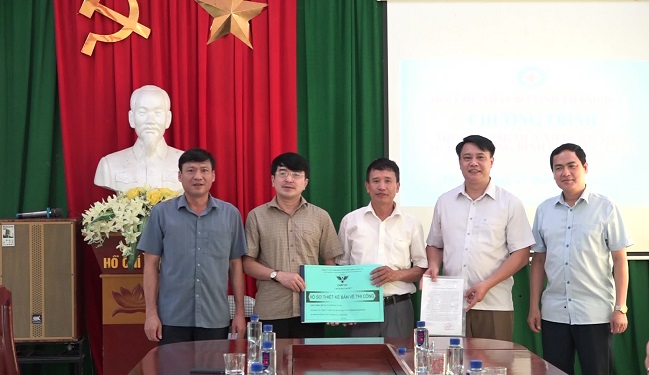 Đồng chí Nguyễn Quốc Thanh, Chủ tịch Hội CTĐ Tỉnh bàn giao hồ sơ thiết kế bản vẽ thi công công trình bếp ăn bán trú tại trường Tiểu học Pù Nhi cho lãnh đạo nhà trường