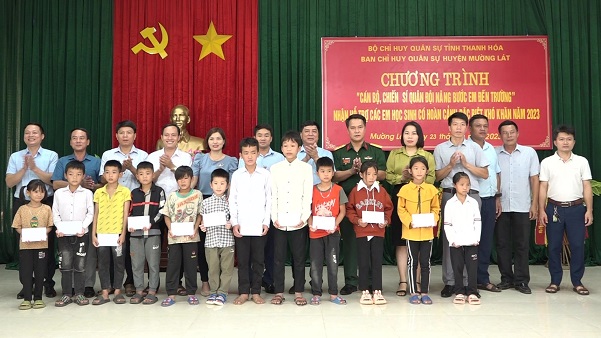 Lãnh đạo huyện và Ban CHQS huyện trao quyết định và kinh phí hỗ trợ nhận nuôi cho các em học sinh người dân tộc thiểu số có hoàn cảnh đặc biệt khó khăn.