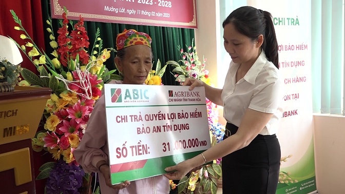 Bà Ngô Thị Nhạn, Phó Trưởng phòng Kinh doanh Tây Thanh Hóa trao số tiền bảo hiểm cho thân nhân khách hàng gặp rủi ro trong quá trình vay vốn và tham gia bảo hiểm tự nguyện tại Agribank.