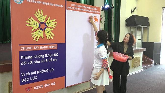 Các thành viên câu lạc bộ “Thủ lĩnh của sự thay đổi” in dấu tay màu cam chung tay phòng, chống bạo lực gia đình