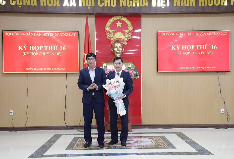 Đồng chí Nguyễn Ngọc Tiến, Ủy viên Ban Thường vụ, Trưởng Ban Nội chính Tỉnh ủy tặng hoa Tân Chủ tịch UBND huyện Mường Lát Trịnh Văn Thế.